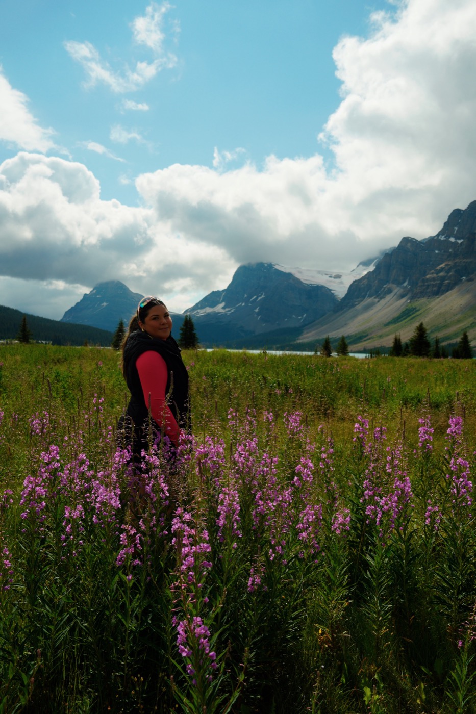 Zaira standing among wildflowers in the Canadian Rockies